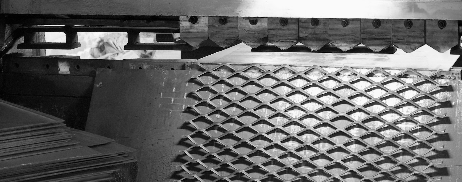 鋼板網機正在將鋼板進行沖壓擴張，制造鋼板網。
